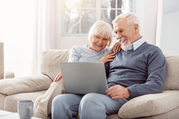 istock Happy couple looking through photos from their trip on laptop 935618090