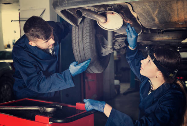 istock Female master with foreman are repairing car 935628428