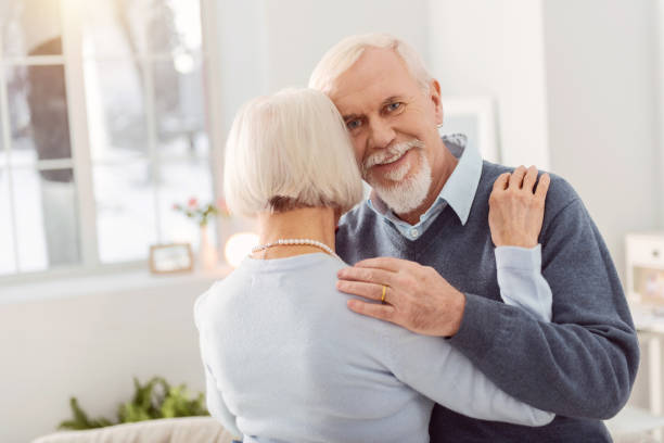 istock Happy senior man smiling while dancing with wife 935639330