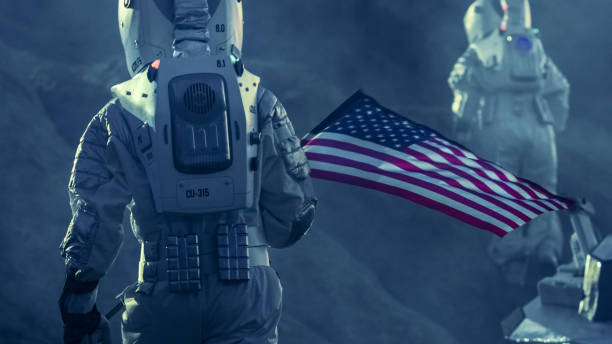 istock Two Astronauts Explore Alien Planet. One Carrying American Flag. Near Future and Technological Advance Brings Space Exploration, Travel, Colonization Concept. 935639546