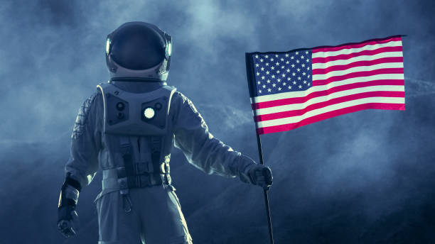 silny astronauta przechodzi przez burzę z flagą stanów ameryki, dumnie spodnie go na dark alien planet. podróże kosmiczne, temat kolonizacji. - people exploration futuristic walking zdjęcia i obrazy z banku zdjęć