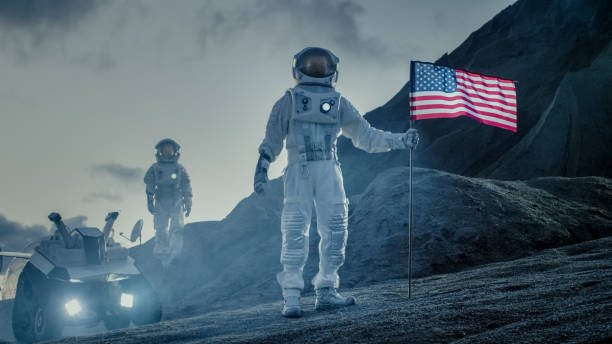 two proud astronauts plant american flag on the alien planet. in the background research base and rover. - smiling research science and technology clothing imagens e fotografias de stock