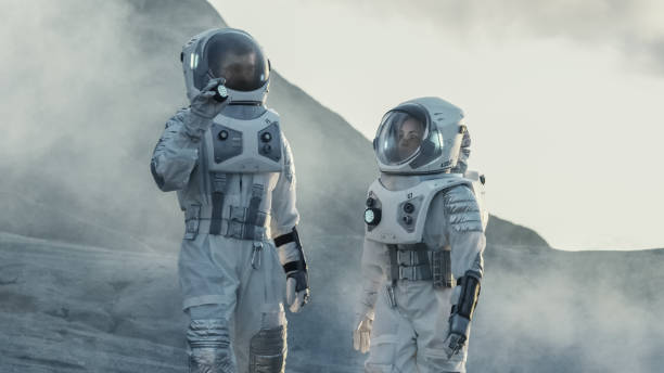 istock Two Astronauts Explore Rocky Alien Planet in the Day Time. Near Future and Technological Advance Brings Space Exploration, Travel, Colonization Concept. 935639632