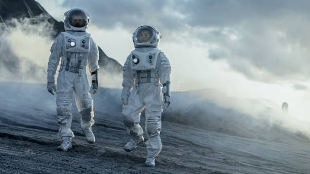 istock Two Astronauts Explore Rocky Alien Planet in the Day Time. Near Future and Technological Advance Brings Space Exploration, Travel, Colonization Concept. 935639664