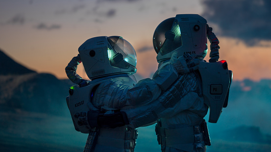 Two Astronauts in Space Suits Hugging on Alien Planet, Exploration of the the Planet's Surface. Love in Space Travel Concept.