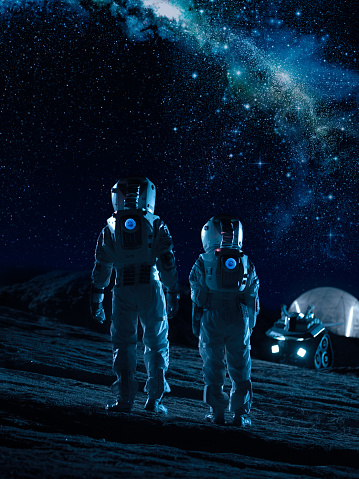 Soporte de dos astronautas en trajes espaciales en los planetas alienígenas mirando las estrellas en manera lechosa Galaxia. Recorrido de espacio y concepto de colonización extraterrestre. photo
