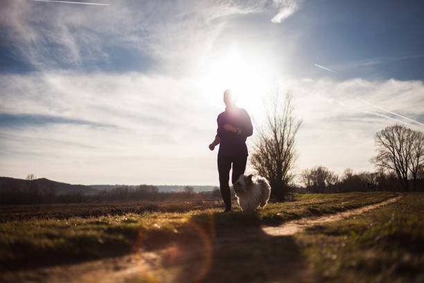 istock Senior woman running with dog 935639836