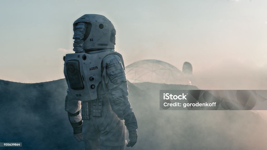 Shot of the Astronaut on Red Planet Watching Toward His Base/Research Station. Near Future First Manned Mission To Mars, Technological Advance Brings Space Exploration, Colonization. Astronaut Stock Photo