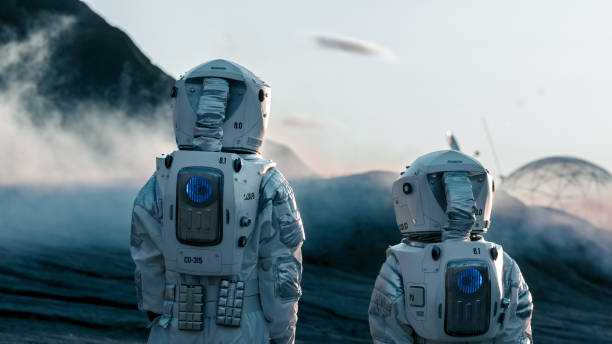 shot of two astronauts confidently walking on alien rocky planet that is covered with gas and smoke. humans overcoming difficulties. scientific progress. - smiling research science and technology clothing imagens e fotografias de stock