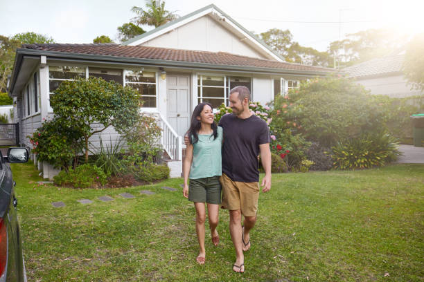 istock Happy mixed-race couple walking outside their front yard garden 935640028