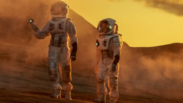 istock Two Astronauts Wearing Space Suits Walk Exploring Mars/ Red Planet. Space Travel and Solar System Colonization Concept. 935640060