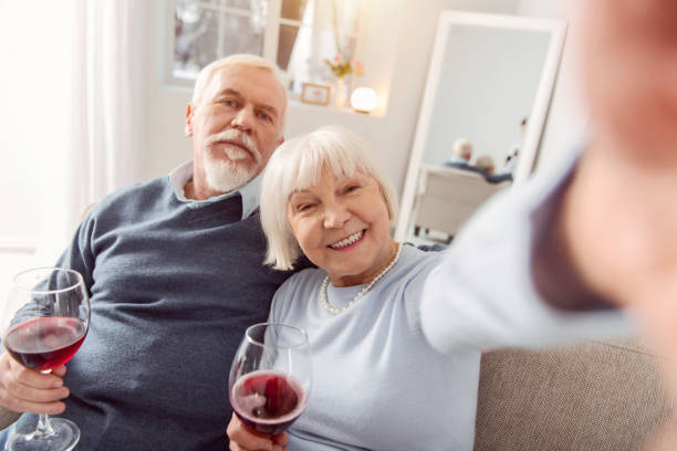 istock Overjoyed senior couple drinking wine and taking selfies 935640150