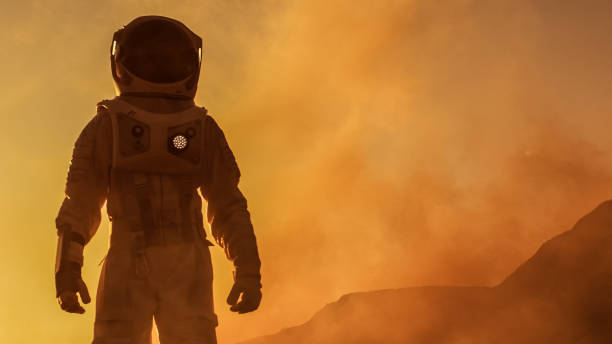 istock Brave Astronaut Confidently Walks on Mars Surface. Red Planet Covered in Gas and rock,  Overcoming Difficulties, Important Moment for the Human Race. 935640222