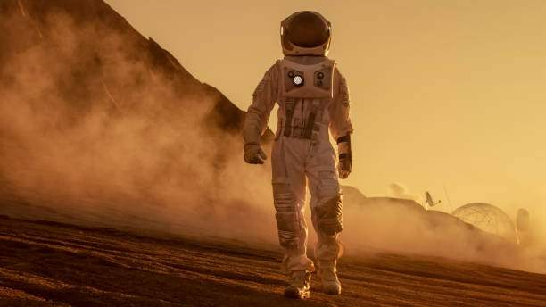 istock Brave Astronaut Confidently Walks on Mars Surface. Red Planet Covered in Gas and rock,  Overcoming Difficulties, Important Moment for the Human Race. 935640250