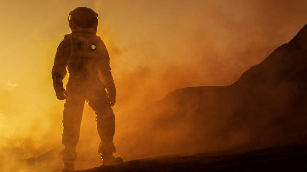 istock Brave Astronaut Confidently Walks on Mars Surface. Red Planet Covered in Gas and rock,  Overcoming Difficulties, Important Moment for the Human Race. 935640292