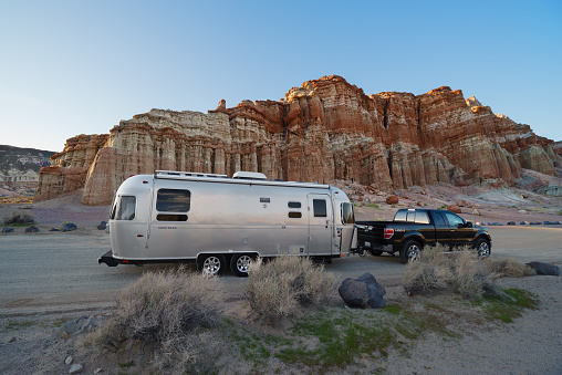 Recreational vehicle shown by the Red Cliffs along California SR 14 (also known as the Antelope Valley Freeway). Red Cliffs are within the Red Rock Canyon State Park in California..