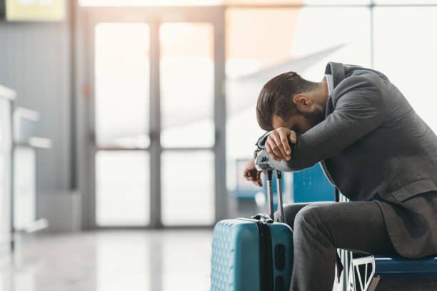 istock tired businessman sleeping at airport lobby while waiting for flight 935644108