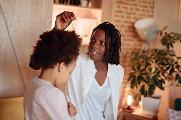 istock Mom fixing daughter's hair 935649418