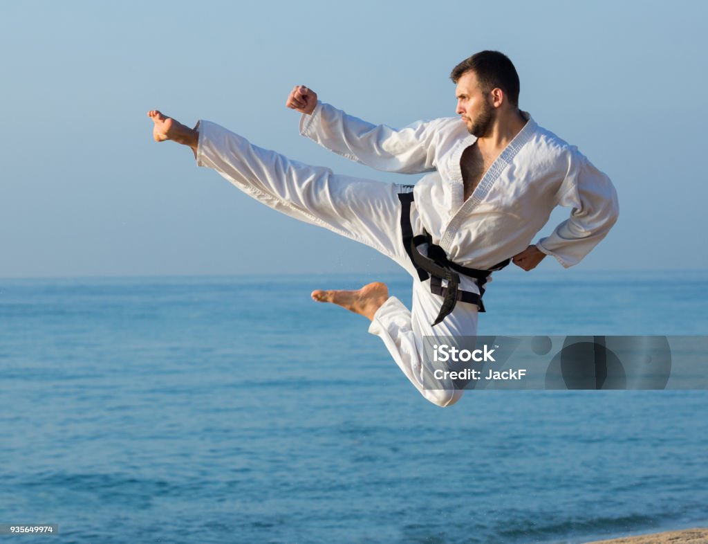 jeune homme pratiquant des positions de Karaté - Photo de Taekwondo libre de droits