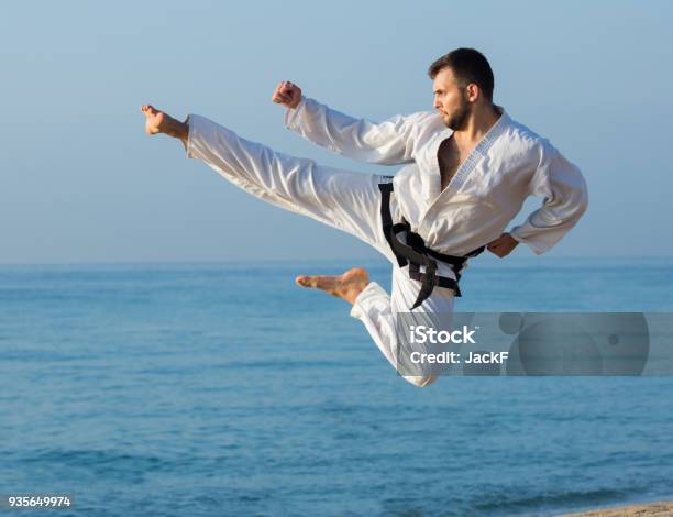 Photo libre de droit de Jeune Homme Pratiquant Des Positions De Karaté banque d'images et plus d'images libres de droit de Taekwondo - Taekwondo, Karaté, Donner un coup de pied