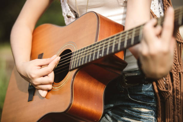 istock Young Asian Hipster playing guitar in the park 935650028