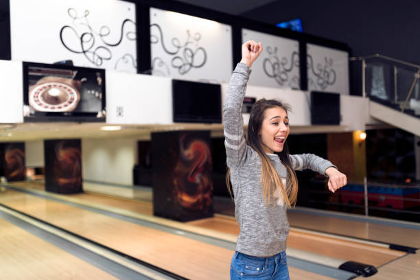 Beautiful lady winning at bowling - celebrating stock photo