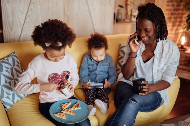 istock Mom talking on the phone while daughters having breakfast 935652458