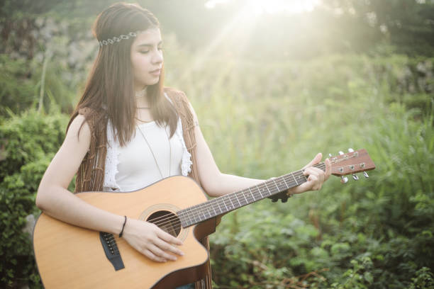 istock Young Asian Hipster playing guitar in the park 935653088