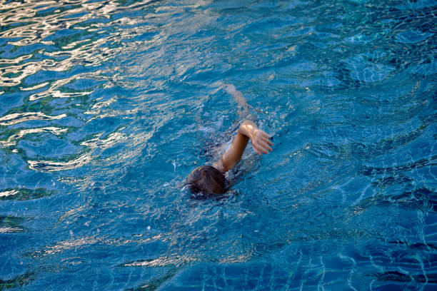 istock Little boy swims in pool 935653224