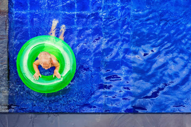 istock Happy child have fun on inflatable ring in swimming pool 935653344