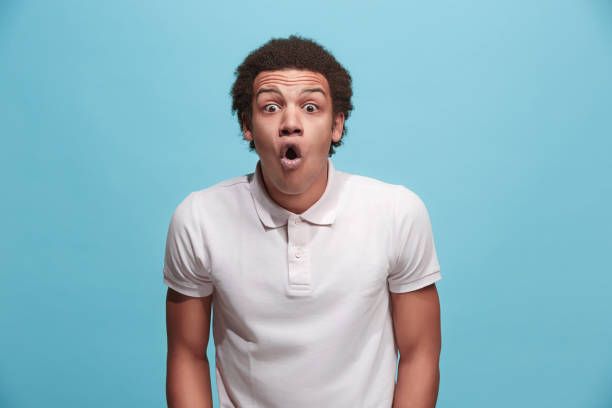The young attractive man looking suprised isolated on pink