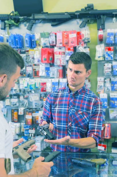 istock guy haelping customer to choose handgun in army market 935659010