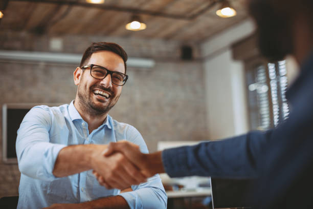 primo tempo di stretta di mano in ufficio - partnership foto e immagini stock