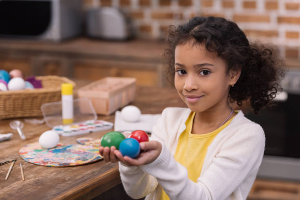 istock african american kid holding painted easter eggs in hands and looking at camera 935660190