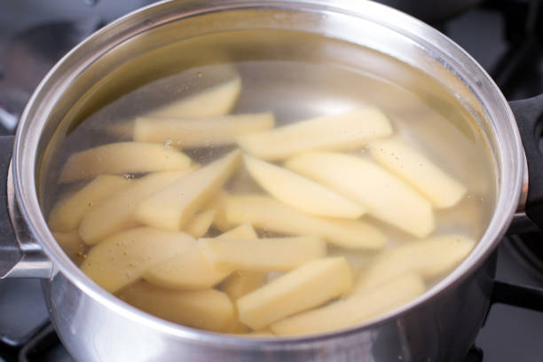 istock Cut potatoes in a saucepan with starting water to boil. 935665498