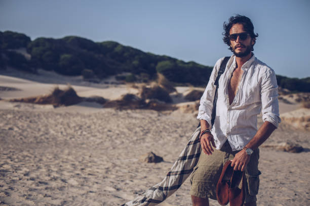 istock Young handsome man standing at the beach 935666028