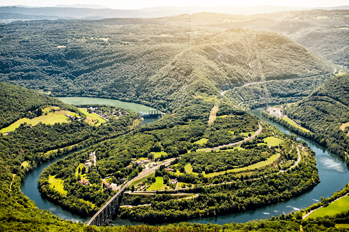 Aerial view of french Ain river valley in horseshoe shape with beautiful old stone viaduct of Cize-Bolozon in Bugey mountains