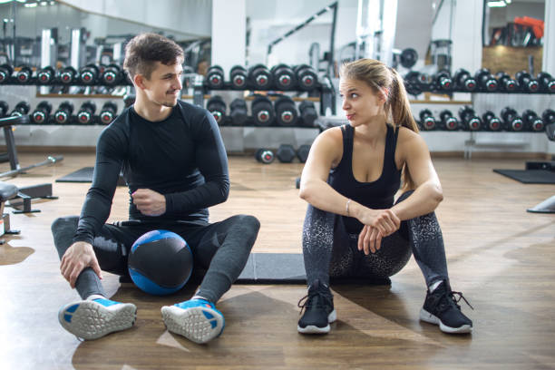 istock Sporty couple talking during exercise break in gym 935674486