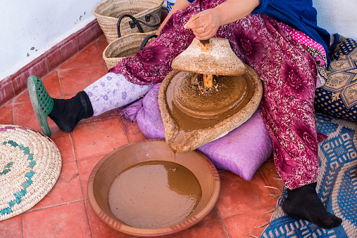 Muslim women making argan oil in traditional way in Morocco. Traditional production of argan oil used for cosmetics and in food preparation