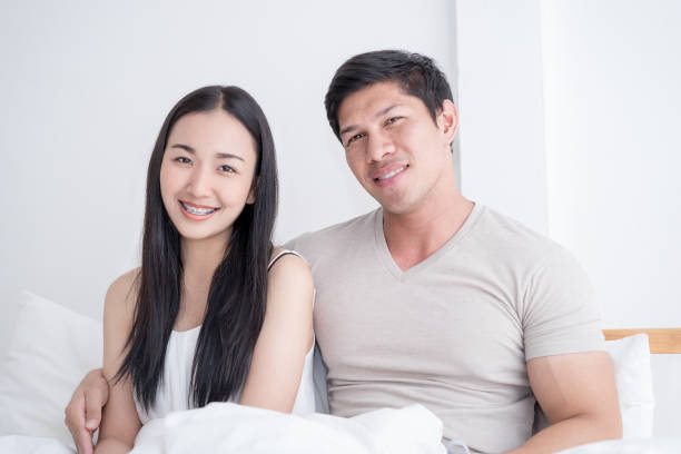 istock Happy Asian couple on bed with bright morning light 935677382