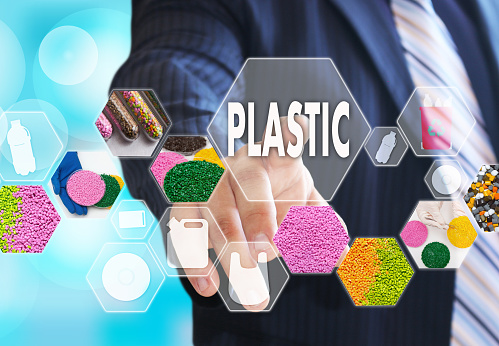 The businessman chooses PLASTIC on the virtual screen in plastic industrial network connection.The concept of raw material plastic in granules