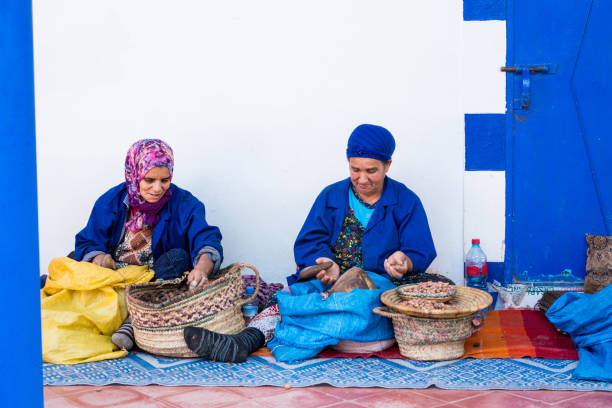 Muslim women making argan oil in traditional way in Morocco. Essaouira, Morocco - November 07, 2017 Muslim women making argan oil in traditional way in Morocco. Traditional production of argan oil used for cosmetics and in food preparation moroccan woman stock pictures, royalty-free photos & images
