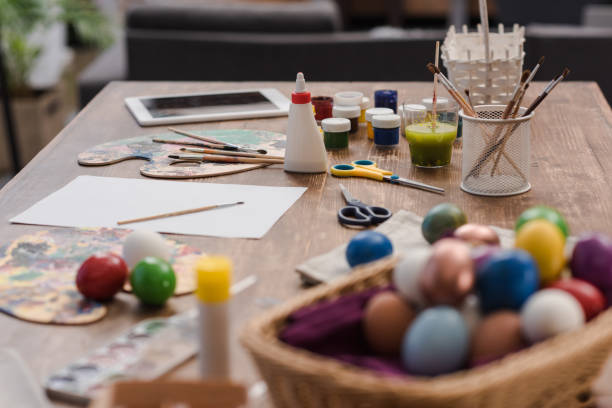 istock painted easter eggs and tools for painting on wooden table 935678824