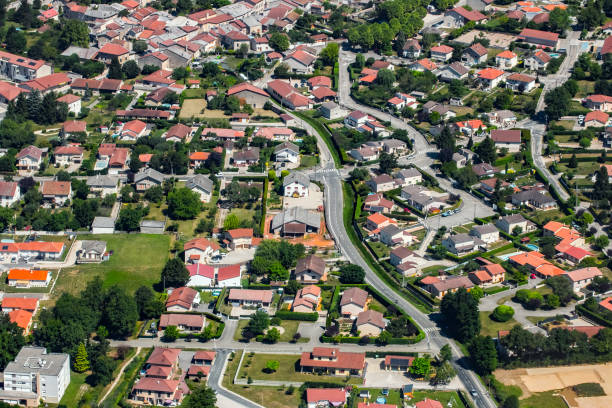 Aerial view of french town of Ambronay in Auvergne-Rhone-Alpes region streets and houses with yard Color photography aerial view of medium size french town, city of Ambronay in Ain, Auvergne-Rhone-Alpes region. High angle view of streets and houses with red roof and yard in summer season during a sunny day. ain france photos stock pictures, royalty-free photos & images
