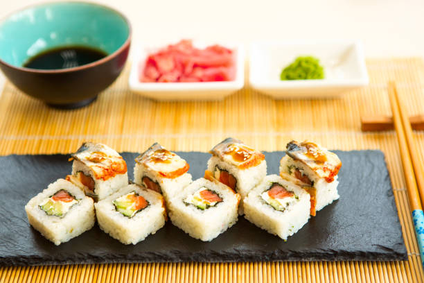 istock Sushi rolls on black slate surface. Japanese food 935685254