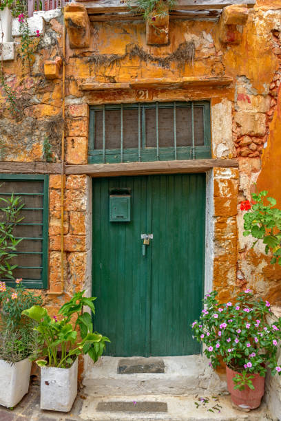 istock Old wall with green locked door and flowers 935685562