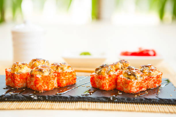 istock Sushi rolls on black slate surface. Japanese food. Hot fried Sushi Roll 935688584