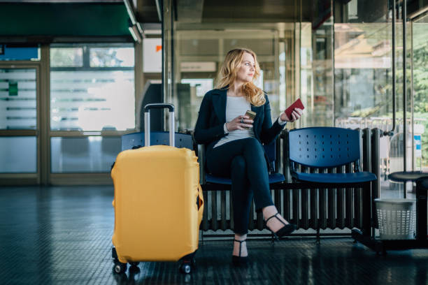 businesswoman waiting for her flight at the airport - people traveling business travel waiting airport imagens e fotografias de stock
