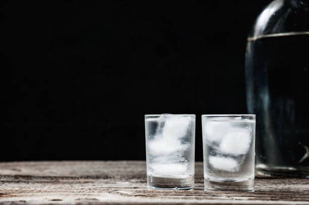 istock Cold vodka in shot glasses on a black background 935691142