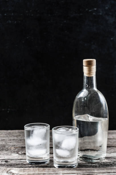 istock Cold vodka in shot glasses on a black background 935691490